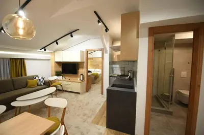 a kitchen and living room with a couch and a table at Apartmani Marija in Kopaonik