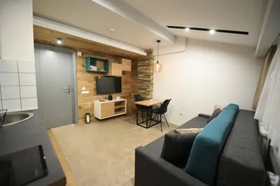 a living room with a blue couch and a table at Apartmani Marija in Kopaonik