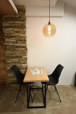 a table and two chairs in a room with a light at Apartmani Marija in Kopaonik