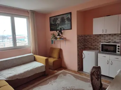 a kitchen with a couch and a chair in a room at Apartman UNA in Kruševac