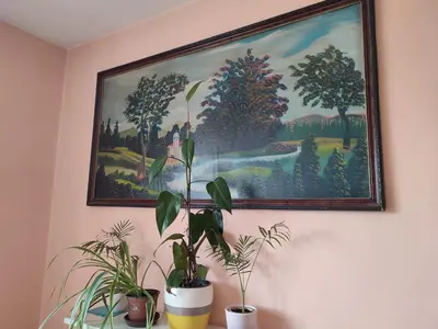 a painting hanging on a wall with potted plants at Apartman UNA in Kruševac