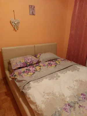 a bed with flowers on it in a bedroom at Apartman UNA in Kruševac