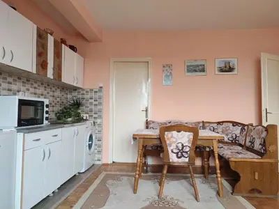a kitchen with a table and a couch at Apartman UNA in Kruševac
