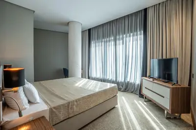 a bedroom with a bed and a flat screen tv at Hotel Tonanti in Vrnjačka Banja