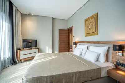 a bedroom with a large bed and a television at Hotel Tonanti in Vrnjačka Banja