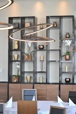 a dining room with a table and a chandelier at Hotel Tonanti in Vrnjačka Banja