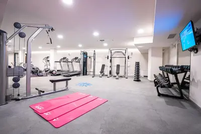 a gym with a pink gym mats and machines at Hotel Tonanti in Vrnjačka Banja