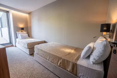 a hotel room with two beds and a window at Hotel Tonanti in Vrnjačka Banja