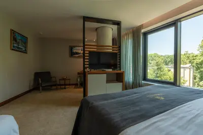 a bedroom with a bed and a flat screen tv at Hotel Tonanti in Vrnjačka Banja