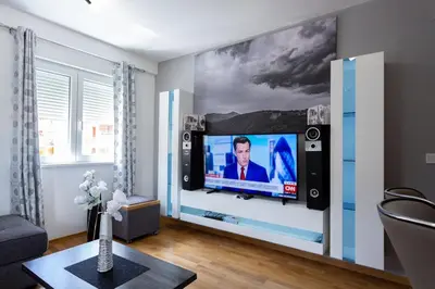 a living room with a flat screen tv on a wall at Apartmani Pezerović in Soko Banja