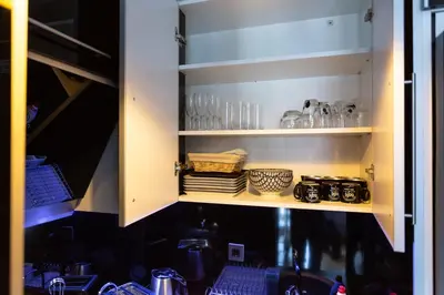 a kitchen cabinet with a sink and some glasses at Apartmani Pezerović in Soko Banja
