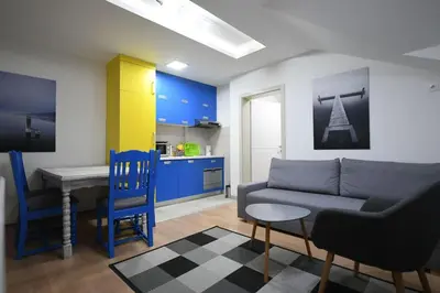 a living room with a couch and a table and a kitchen at Cozy and Lovely Appartment in Jagodina