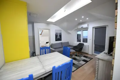 a living room with a table and blue chairs at Cozy and Lovely Appartment in Jagodina