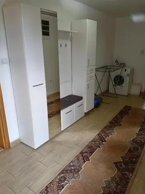 a room with white cabinets and a table and a rug at Vila Viktori in Pirot