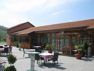 a restaurant with tables and chairs in front of a building at 6 topola in Despotovac