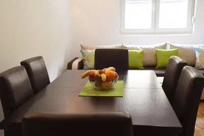 a dining room table with a bowl of fruit on it at Apartman Kaja in Vrnjačka Banja
