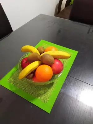 a bowl of fruit with bananas and oranges on a table at Apartman Kaja in Vrnjačka Banja