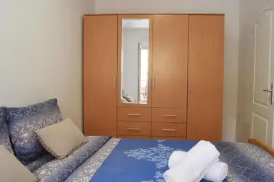 a bedroom with a bed with a dresser and a mirror at Apartman Kaja in Vrnjačka Banja