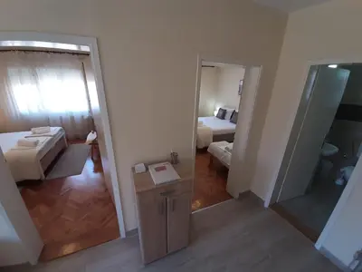 a view of a room with a bed and a mirror at Haus Apartman Zaječar M&L in Zaječar