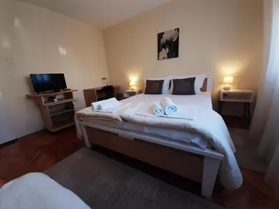 a bedroom with a large bed with towels on it at Haus Apartman Zaječar M&L in Zaječar
