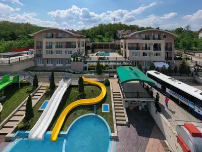 a water park with a slide and a bus at Sunny Hill Apartments & Aqua Park in Vrnjačka Banja