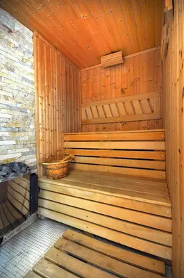 a wooden sauna with a basket in it at Sunny Hill Apartments & Aqua Park in Vrnjačka Banja