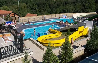 a large swimming pool with people swimming in it at Sunny Hill Apartments & Aqua Park in Vrnjačka Banja