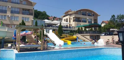 a swimming pool with a slide in a resort at Sunny Hill Apartments & Aqua Park in Vrnjačka Banja