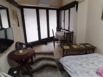 a living room with a bed and a table and chairs at TREF 1 in Soko Banja