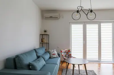 a living room with a blue couch and a table at Apartment Mihajlovic in Vranje