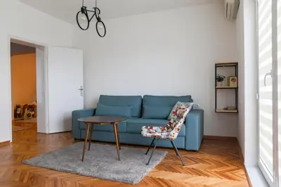 a blue couch in a living room with a table and a chair at Apartment Mihajlovic in Vranje