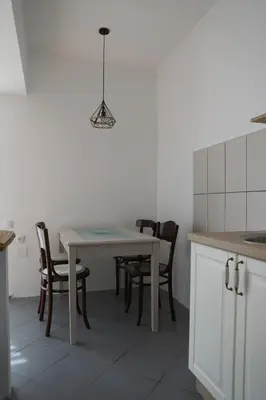 a kitchen with a table with chairs and a light at Apartment Mihajlovic in Vranje