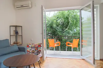a living room with orange chairs and a sliding glass door at Apartment Mihajlovic in Vranje