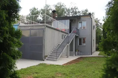 a house with a garage and a staircase on it at Apartman KEJ in Pirot