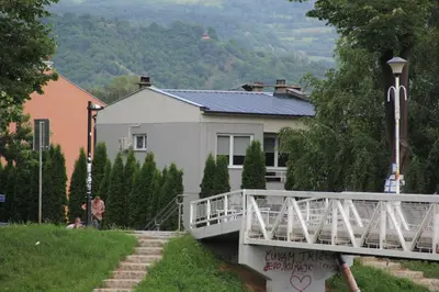 a white house with a bridge in front of it at Apartman KEJ in Pirot