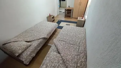 a room with two beds sitting next to a wall at Kopaonik Apartman Aleksandar in Kopaonik