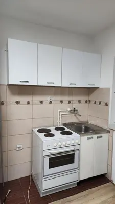 a kitchen with a white stove and a sink at Kopaonik Apartman Aleksandar in Kopaonik