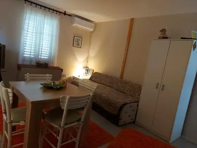 a room with a table and a bedroom with a bed at Apartman Kućica za odmor , Drašković in Vrnjačka Banja