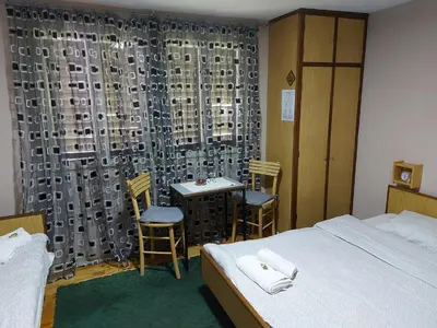 a bedroom with a bed and a table and chairs at Apartman Kućica za odmor , Drašković in Vrnjačka Banja