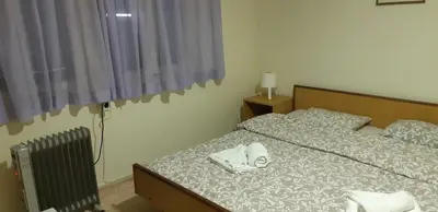 a bedroom with a bed with two white towels on it at Apartman Kućica za odmor , Drašković in Vrnjačka Banja