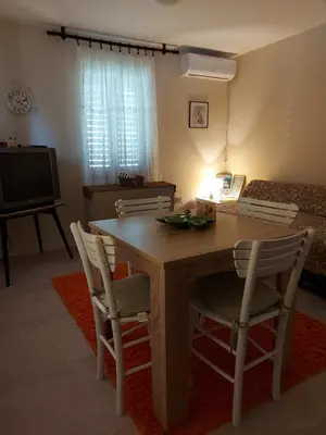 a living room with a wooden table and chairs at Apartman Kućica za odmor , Drašković in Vrnjačka Banja