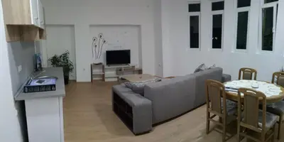 a living room with a gray couch and a table at Apartmani MIDUĆI in Vrnjačka Banja