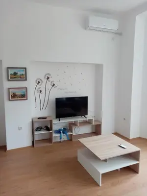 a living room with a tv and a coffee table at Apartmani MIDUĆI in Vrnjačka Banja