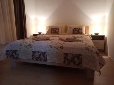 a bedroom with a bed with a floral bedspread at Apartmani MIDUĆI in Vrnjačka Banja