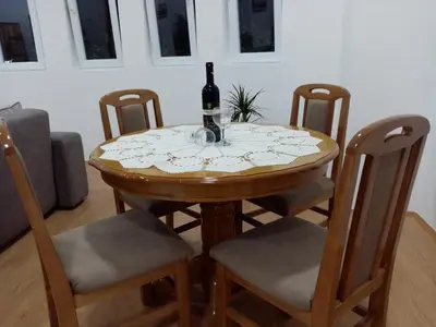 a table with a bottle of wine sitting on it at Apartmani MIDUĆI in Vrnjačka Banja