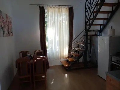 a living room with a staircase and a suitcase at Apartmani MIDUĆI in Vrnjačka Banja