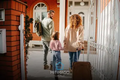 a man and a woman and a child walking out of a house at Lux Villa Mitimago in Niš