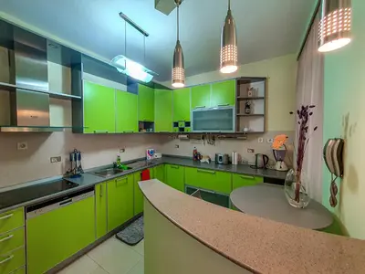 a green kitchen with green cabinets and a counter at Lux Villa Mitimago in Niš