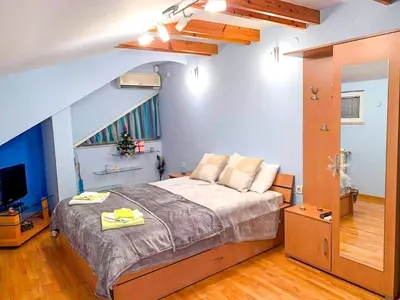 a bedroom with a large bed and a television at Lux Villa Mitimago in Niš