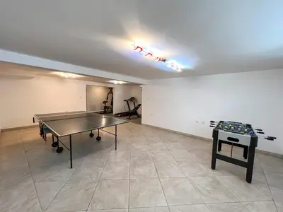 an empty room with a ping pong table in it at Lux Villa Mitimago in Niš
